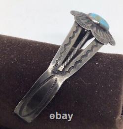 A vintage Fred Harvey sterling silver bracelet with a turquoise cabochon center